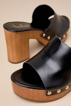 The Lulus Jaylani Black Platform Mule Sandals are the perfect combination of cute and cool for all your warm weather 'fits! Smooth faux leather shapes these essential sandals that have an almond footbed and a wide vamp strap with shiny gold stud accents along the side, all atop a 1.25"" toe platform. Easy slide-on design makes for effortless, everyday styling, while a sturdy wood-look block heel completes the classic clog-inspired look! 3. 75" wood-look block heel. Lightly cushioned insole. Rubb Gold Leather Heels For Vacation, Elegant Open Toe Clogs For Summer, Elegant Open Toe Summer Clogs, Trendy Gold Leather Sandals, Chic Open Toe Clogs With Stacked Heel, Chic Block Heel Clogs For The Beach, Chic Leather Beach Clogs, Chic Leather Clogs For Summer, Chic Open Toe Clogs With Cushioned Footbed