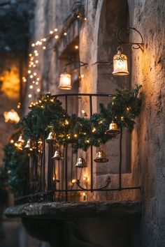 christmas lights are hanging on the side of an old building with bells and wreaths