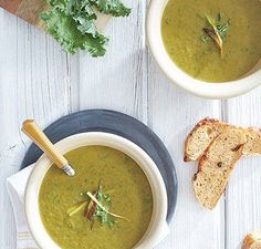 two bowls of soup with bread on the side