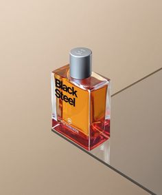 a bottle of black steel cologne sitting on top of a glass table next to a wall