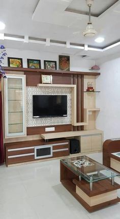 a living room filled with furniture and a flat screen tv mounted on a wall above a glass coffee table