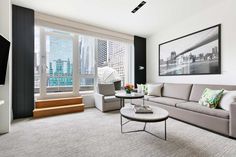 a living room filled with furniture and a flat screen tv mounted to the side of a wall