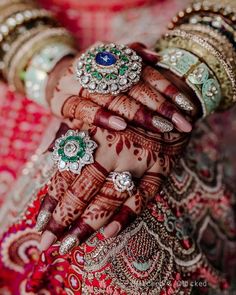 a woman's hands with rings and jewelry on them