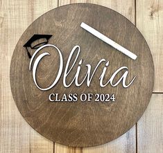 a wooden sign that says,'olvia class of 2014'with a graduation cap and diploma on it