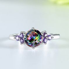 A ring as unique as you are! This sterling silver ring is set with a rainbow topaz and an amethyst, both of which have been faceted to catch the light. The result is a ring that's dazzling and eye-catching, perfect for any special occasion. Throughout history, mystic topaz has been associated with healing and good luck. As well as bringing good fortune, the stone is believed to have the power to ward off evil (or negative energy) while boosting your energy and positive feelings. Metals Type: 925 Positive Feelings, Rainbow Topaz, Amethyst Stones, Love And Friendship, Wedding Band Sets, Mystic Topaz, Gem Stone, Amethyst Stone, 925 Jewelry