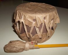 an old drum is sitting on the table next to a pencil and paper wrapper