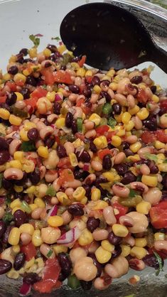 a bowl filled with beans and vegetables on top of a table