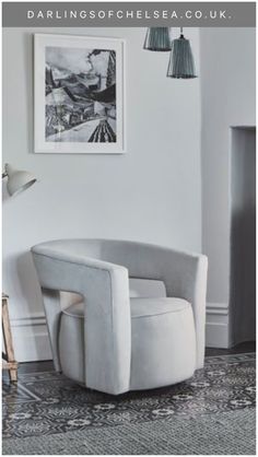 a white chair sitting in front of a painting