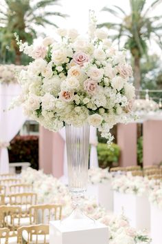 a tall vase filled with white and pink flowers