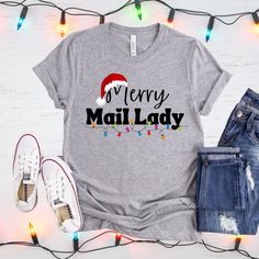 Mail Lady Christmas Shirt Mail Lady Gift Rural Carrier Shirt Postal Worker Shirt Christmas T-Shirt Mail Carrier T-Shirt Postal Clothes This t-shirt is everything you've dreamed of and more. It feels soft and lightweight, with the right amount of stretch. It's comfortable and flattering for both men and women.  * 100% combed and ring-spun cotton (Heather colors contain polyester) * Ash color is 99% combed and ring-spun cotton, 1% polyester * Heather colors are 52% combed and ring-spun cotton, 48% polyester * Athletic and Black Heather are 90% combed and ring-spun cotton, 10% polyester * Heather Prism colors are 99% combed and ring-spun cotton, 1% polyester * Fabric weight: 4.2 oz (142 g/m2) * Pre-shrunk fabric * Shoulder-to-shoulder taping * Side-seamed FULFILLMENT TIMES Our products are ma Ladies Christmas Shirts, Rural Carrier, Merry Mail, Mail Carrier, Postal Worker, Christmas T Shirt, Ash Color, Christmas Shirt, Christmas Tshirts