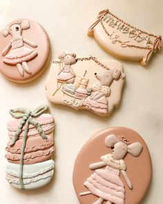 four decorated cookies on a table with decorations in the shape of mice and mouses