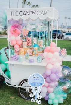 the candy cart is decorated with balloons, candies and other items for an outdoor party