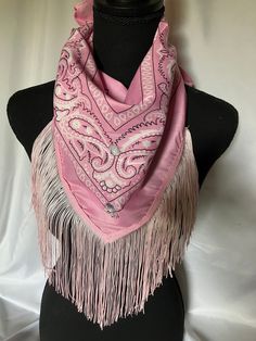 a pink scarf with fringes on top of a mannequin