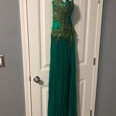 a green dress hanging on a door