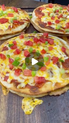 three pizzas with different toppings sitting on top of a wooden table