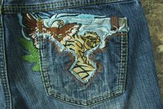 the back pocket of a pair of jeans with embroidered designs on them and an eagle