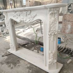 an ornate white fireplace surround is being worked on