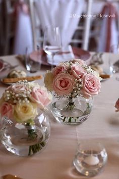 three vases with flowers are sitting on a table in the middle of a banquet