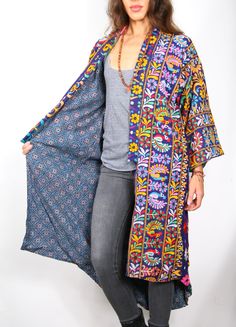 Our “Vintage Mirrored Kimono Coat” is a unique, one of a kind coat. The kimono is made from hand made embroidery mirrored fabric famous from the Rajasthan region of India. One of a kind Vintage (old) embroidered cloth’s are carefully selected by us and mixed and mended and sewn together and stacked in a whimsical hand made way. The Kimono coats are lined with soft hand printed cotton fabric. This unique item is a fabric & fashion lovers dream, and the coat is such a cool Artsy look. The coat is Multicolor Floral Embroidered Kimono For Fall, Fall Outerwear With Embroidered Kimono Sleeves, Fall Embroidered Outerwear With Kimono Sleeves, Floral Embroidered Long Outerwear For Festivals, Traditional Silk Outerwear For Spring, Long Floral Embroidered Outerwear For Festivals, Long Embroidered Fall Kimono, Bohemian Silk Outerwear For Winter, Spring Festival Outerwear With Geometric Embroidery