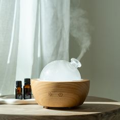 a wooden bowl filled with white liquid sitting on top of a table next to bottles