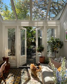 a living room filled with furniture and lots of windows covered in sun shining through the roof