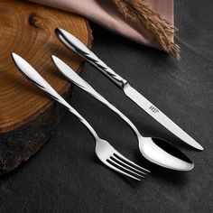 three forks and two knives on a table