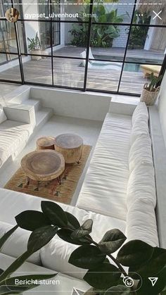 a living room filled with white couches and tables