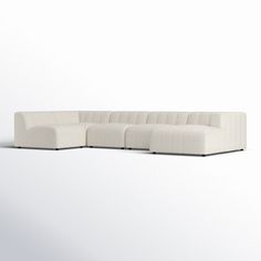 a white sectional couch sitting on top of a white floor