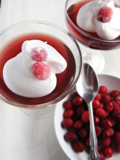 two glasses filled with dessert and berries on a table