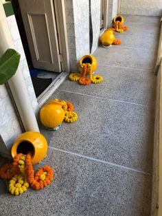 some yellow vases with flowers on the side of a building next to a door