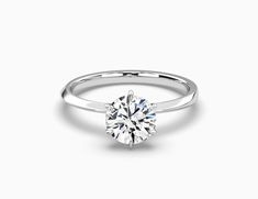 a round brilliant cut diamond engagement ring on a white background with the center stone visible