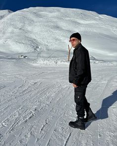 a man standing on top of a snow covered slope