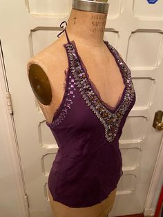 Silk, polyester, and Rayon, dark purple beautiful halter tank top from the 80's. Fairly heavy from the beading, nice weight! Beautiful beaded design around neck line. Perfect for a night out or a sunny day!  Size: M length: 21" waist: 29" bust: (adjustable) roughly 36" Fitted Purple Tank Top For Night Out, Embellished Halter Neck Top For Summer, Purple Camisole Tank Top For Party, Purple Sleeveless Tank Top For Party, Glamorous Halter Neck Tank Top For Evening, Glamorous Sleeveless Halter Top For Festival, Embellished Sleeveless Halter Top For Summer, Glamorous Halter Neck Evening Tank Top, Glamorous Sequined Halter Neck Tank Top