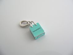 Overview: Here is a gift that she will surely adore! It is THE classic Tiffany piece - super pretty, stylish, and very versatile! This "Shopping Bag" will make someone REALLY happy! :) Offered for sale is a wonderful Tiffany & Co. Sterling Silver & "Tiffany" Blue enamel Shopping Bag charm. Just attach it to an existing chain or cord that you already have and voila! - Instant Tiffany style! :) Included with the charm is a Tiffany & Co. Silver Oval Clasp that allows you to attach the charm very ea Luxury Bags With Logo Charm For Gift, Modern Blue Bags For Gifts, Modern Blue Bags As Gifts, Modern Blue Bag For Gifts, Gift Love, Tiffany Style, Tiffany Blue, Silver Blue, Tiffany & Co.