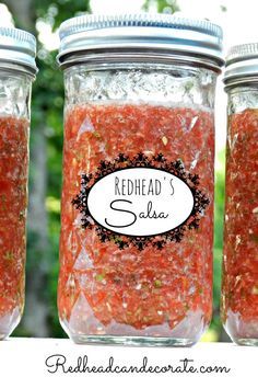 three jars filled with red stuff sitting on top of a table