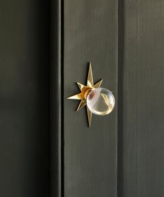 a door handle with a star decoration on it's side and a glass ball in the middle