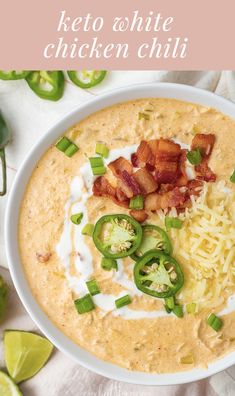 a white bowl filled with soup and topped with bacon, green onions, cheese and jalapenos