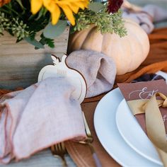 a place setting with sunflowers and pumpkins on the table for thanksgiving dinner