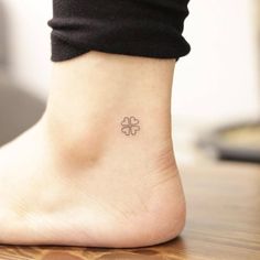 a small four leaf clover tattoo on the left side of the foot, which is attached to an ankle