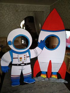 a cardboard cut out of an astronaut standing next to a rocket ship