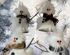 three snowmen with hats and scarves on their heads are hanging from a christmas tree