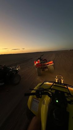 two atvs driving in the desert at sunset with one being pulled by a vehicle