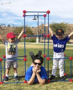 two children and an adult posing in front of a building made out of lego blocks