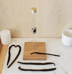 several different types of hair accessories on a table with a cup and vase in the background