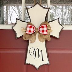 the front door is decorated with a red and white checkered bow, plaid ribbon, and monogrammed letters