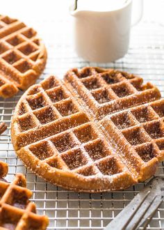 two waffles sitting on top of a cooling rack next to a cup of coffee