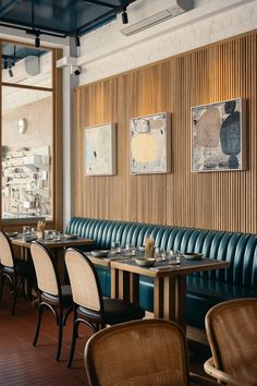 an empty restaurant with blue leather booths and wood paneling on the wall behind them