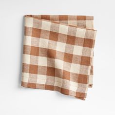 two brown and white checkered napkins sitting on top of each other