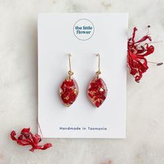 the little flower handmade earrings are red with gold flecks and dangles