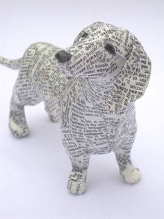 a dog made out of newspaper paper on a white surface with the words written all over it